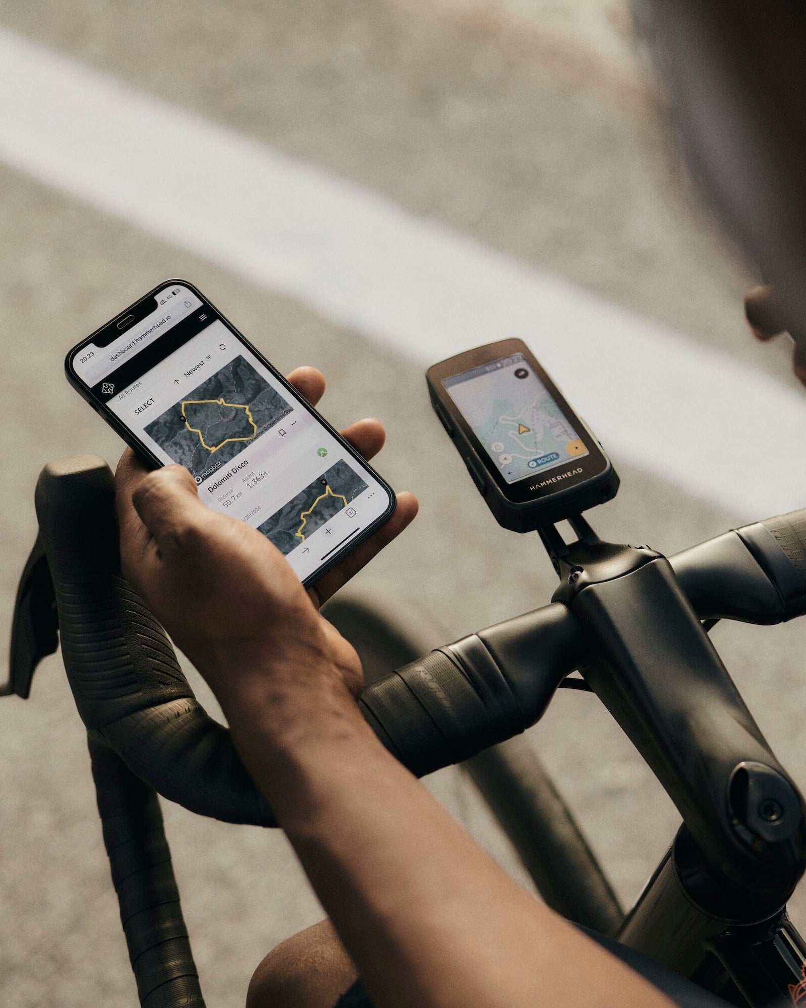 Person using a smartphone app on a bicycle with a GPS device.