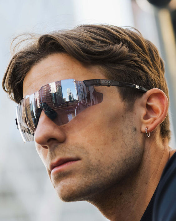 Man wearing reflective sunglasses with a blurred background